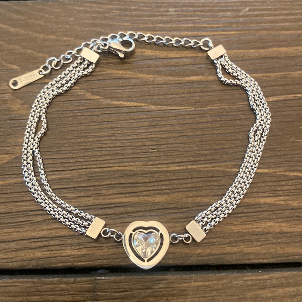 SILVER TITANIUM STEEL THREE CHAIN BRACELET ACCENTED WITH CLEAR CRYSTAL HEART